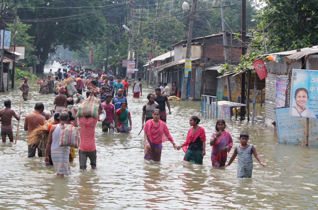 Residents wade through flood waters in the Indian state of West Bengal on August 17.