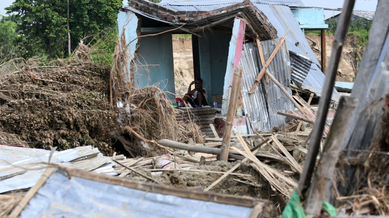 A man rests in his house damaged by flooding some 250 kilometers from Nepal's capital Kathmandu on August 16.