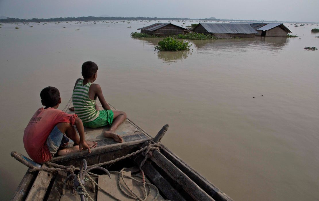 Flood-affected villagers travel by boat in floodwaters in the Morigaon district in the northeastern Indian state of Assam on August 15. 