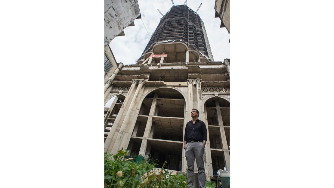 Pansit Torsuwan, owner of the Sathorn Unique Tower, stands beside the abandoned structure. 