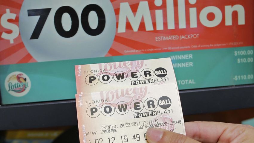 A customer shows her purchased Powerball tickets for Wednesday's drawing, Tuesday, Aug. 22, 2017, in Hialeah, Fla. The winner could take the $700 million annuity option (paid out over 29 years) or the $443.3 million cash prize, minus state and federal taxes. (AP Photo/Alan Diaz)