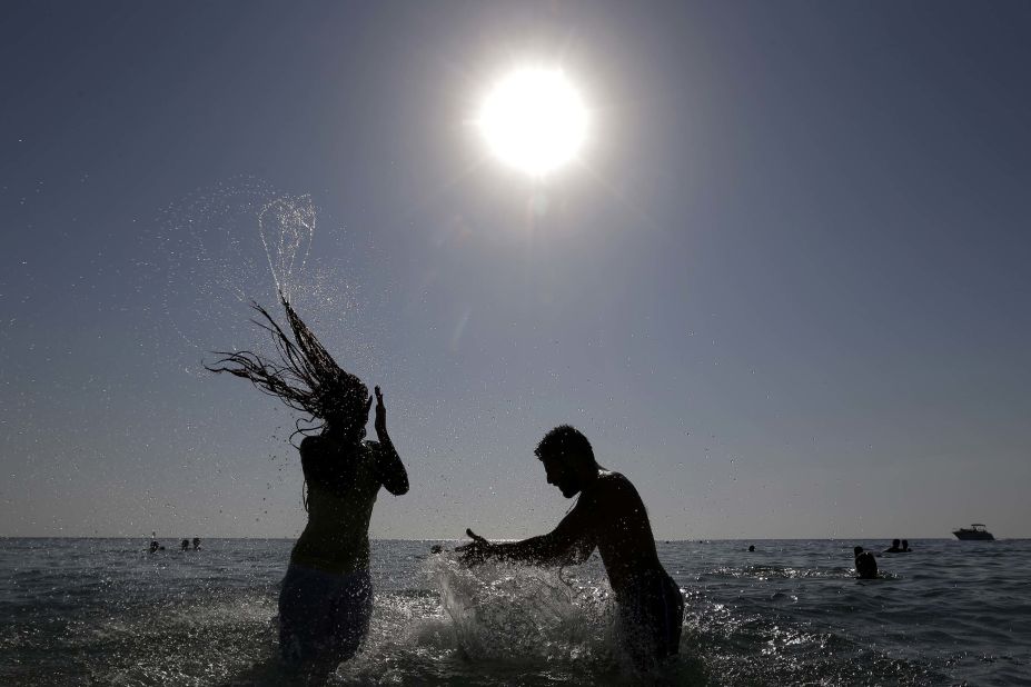 A Lebanese couple enjoy themselves in the water at the beach of the southern port city of Tyre, Lebanon.
