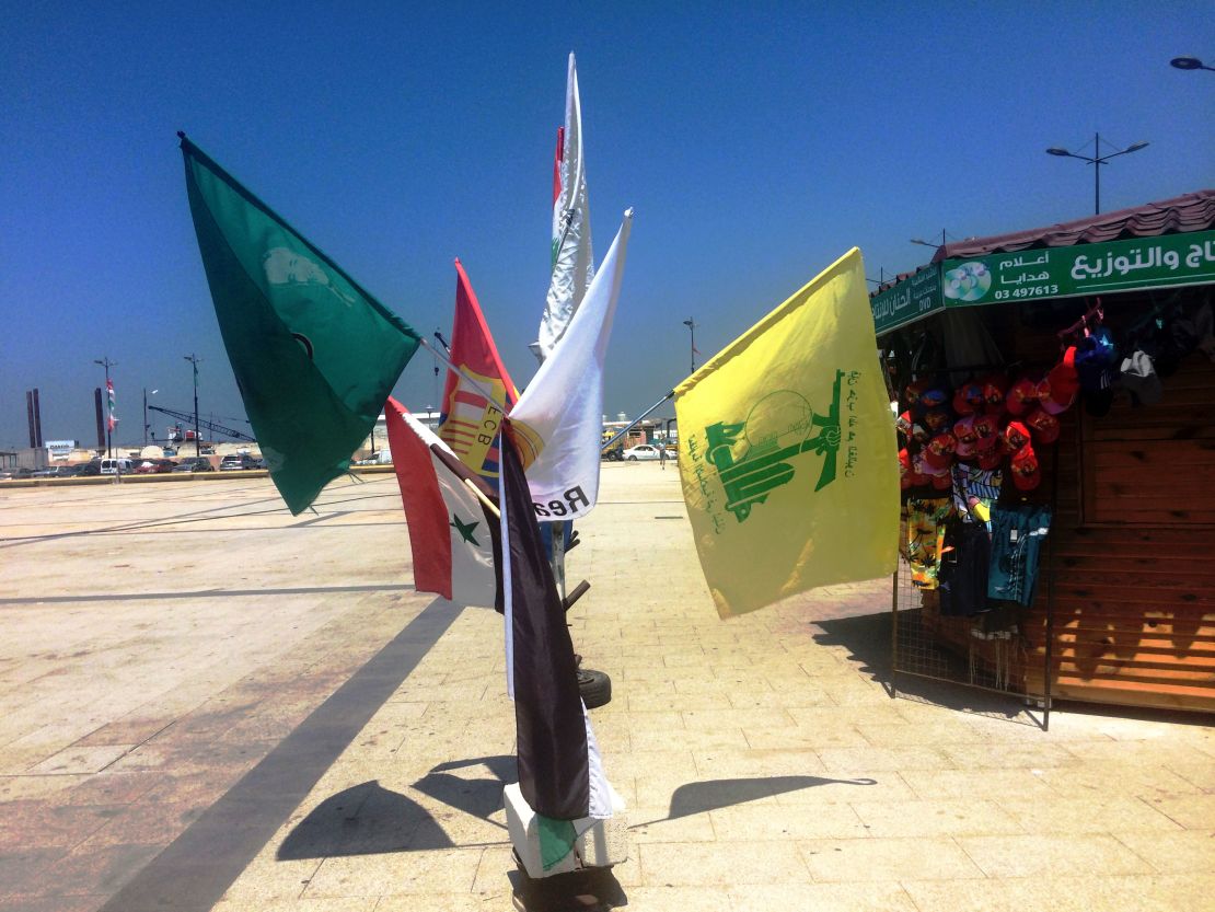The yellow and green flag of political party and militant group Hezbollah (right) for sale at a stall in Tyre alongside those of soccer clubs FC Barcelona and Real Madrid.
