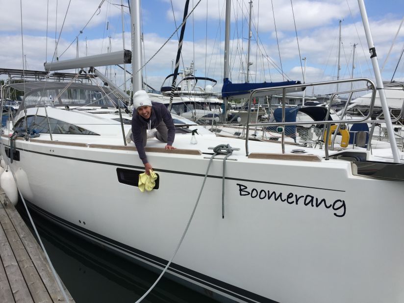 Kellie gives their boat, "Boomerang", a good polish before its maiden voyage.