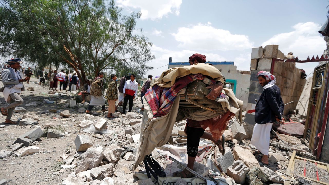 A Yemeni man carries his belongings after an airstrike heavily damaged his neighborhood.
