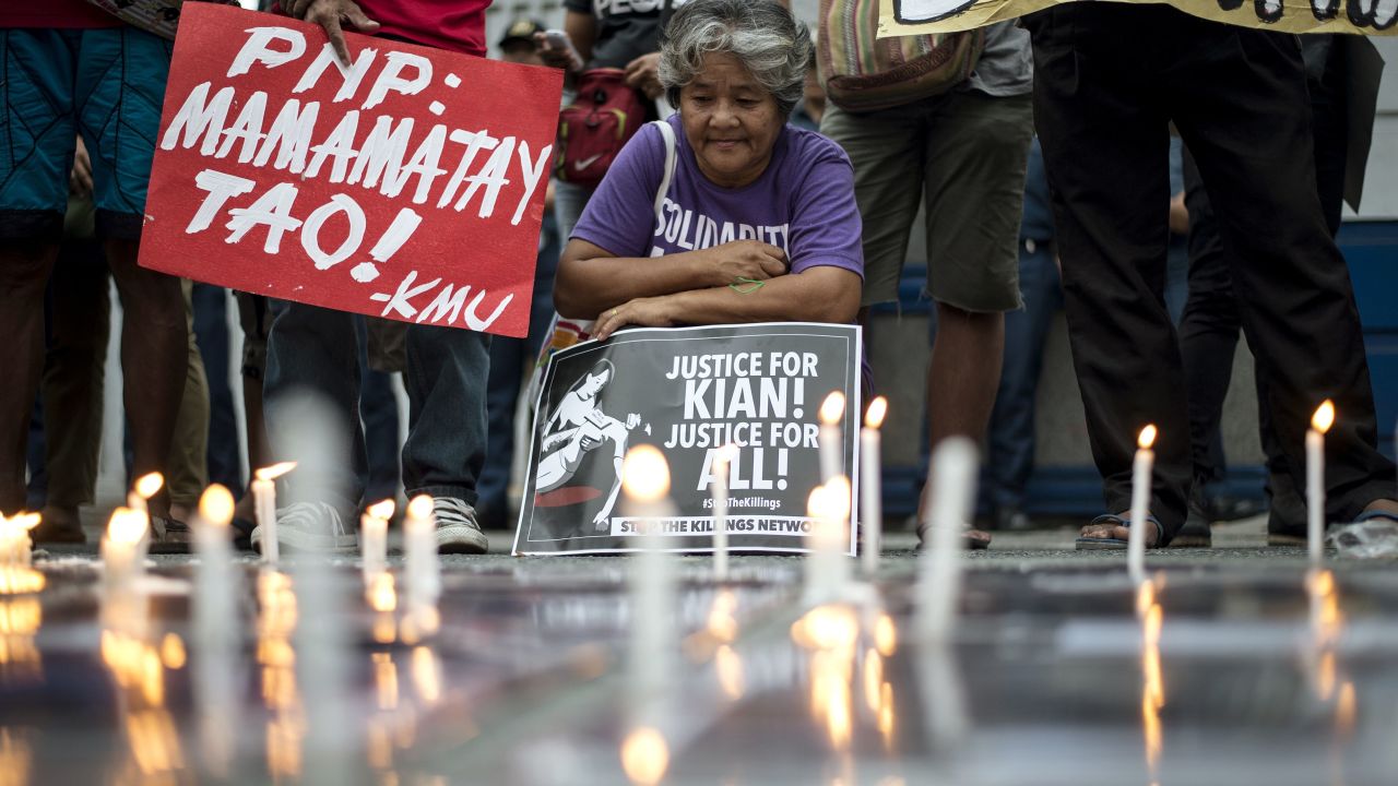 An activist holds a poster against extra-judicial killings during a protest in Manila on August 23, 2017. 