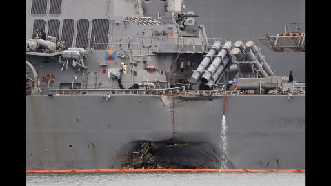 The damaged port aft hull of the USS John S. McCain, is visible while docked at Singapore's Changi naval base on Tuesday, Aug. 22.