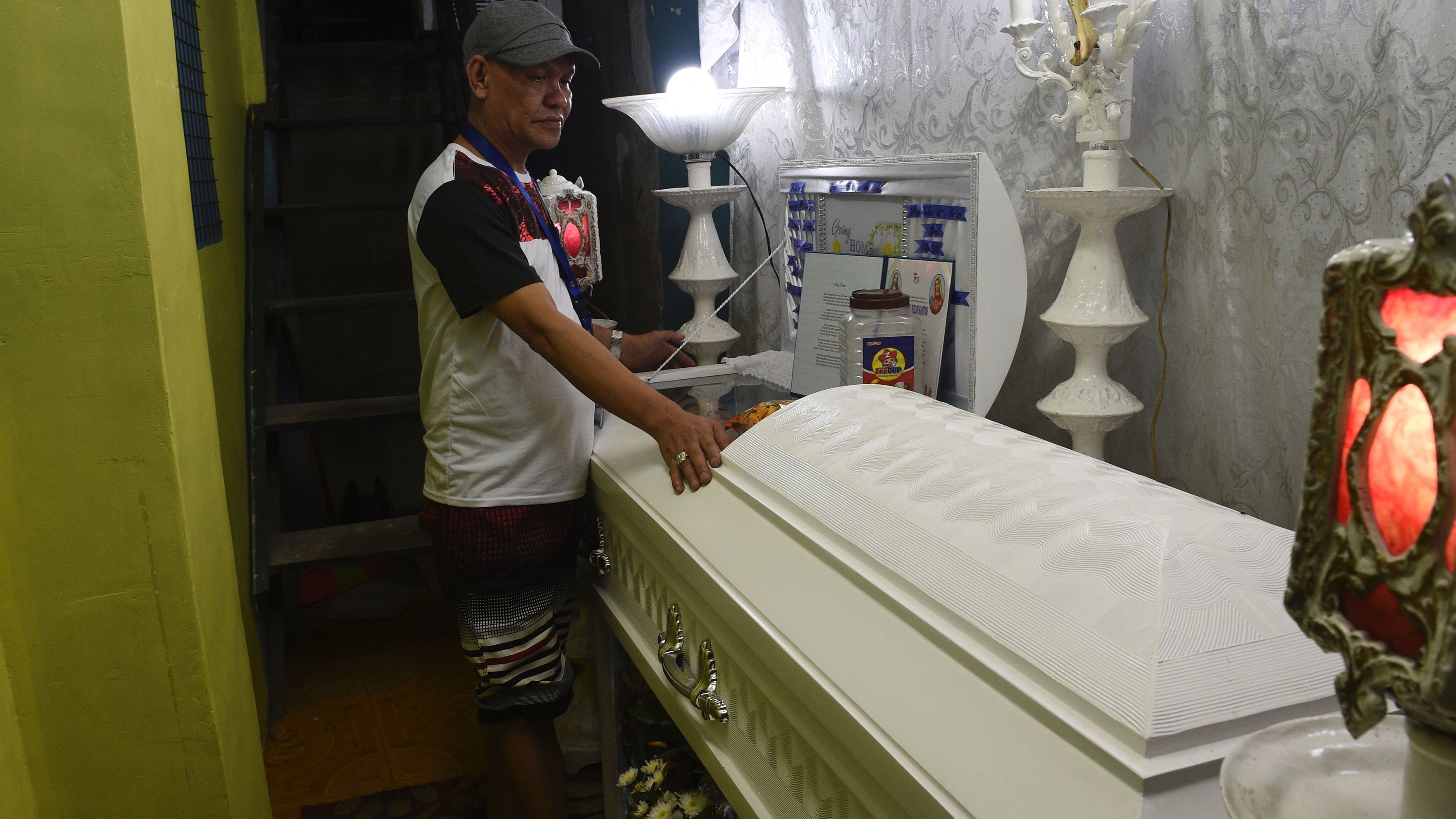Kian Delos Santos' father Saldy stands next to the coffin of his son, allegedly killed by a police anti-drug raid, during a wake at his home in Manila in August 2017. 
