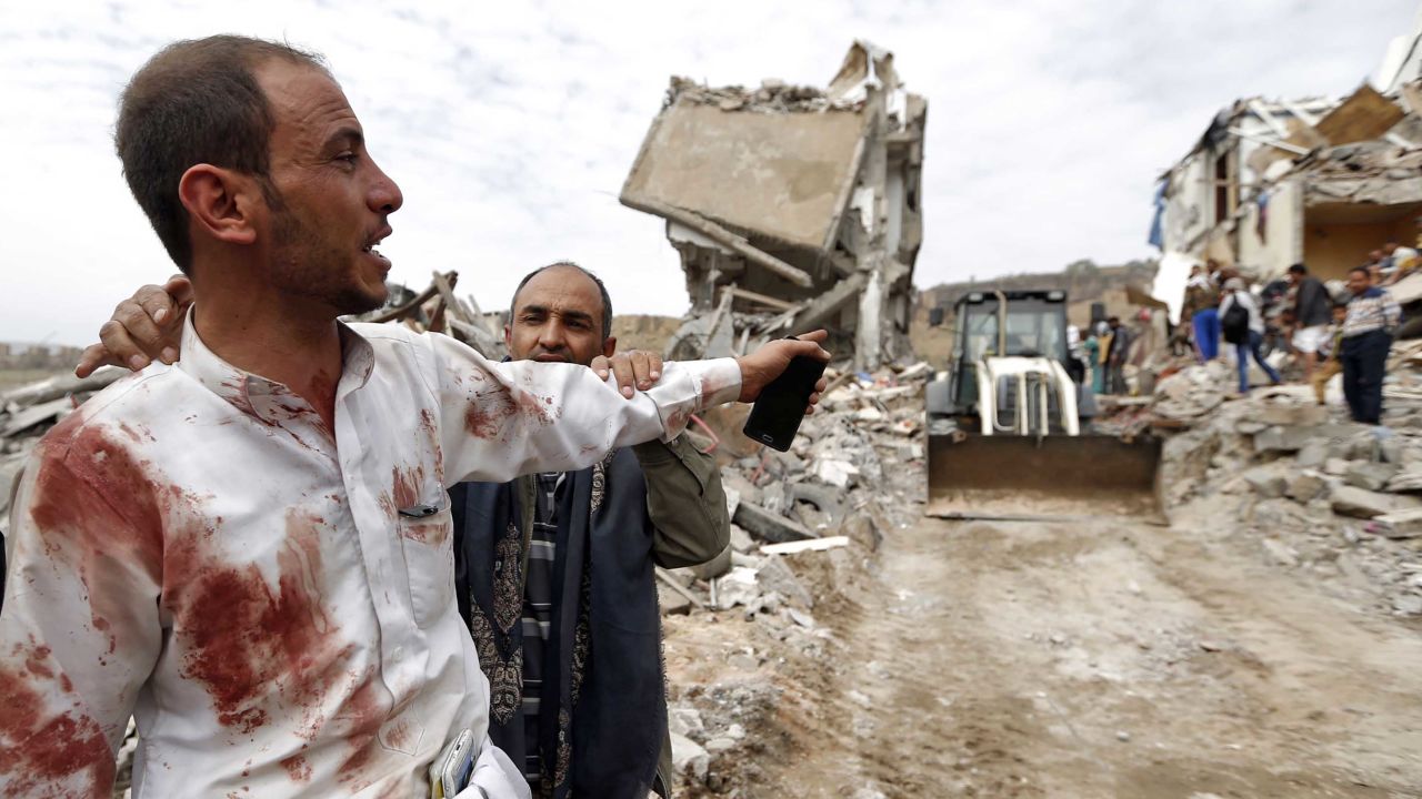 A Yemeni man covered in blood reacts as people search for survivors following Friday's strike.