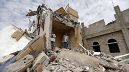 Yemenis stand in the rubble of a house destroyedin an air strike in the residential southern Faj Attan district of the capital, Sanaa, on August 25, 2017.The attack destroyed two buildings in the southern district, leaving people buried under debris, witnesses and medics said. / AFP PHOTO / Mohammed HUWAIS        (Photo credit should read MOHAMMED HUWAIS/AFP/Getty Images)