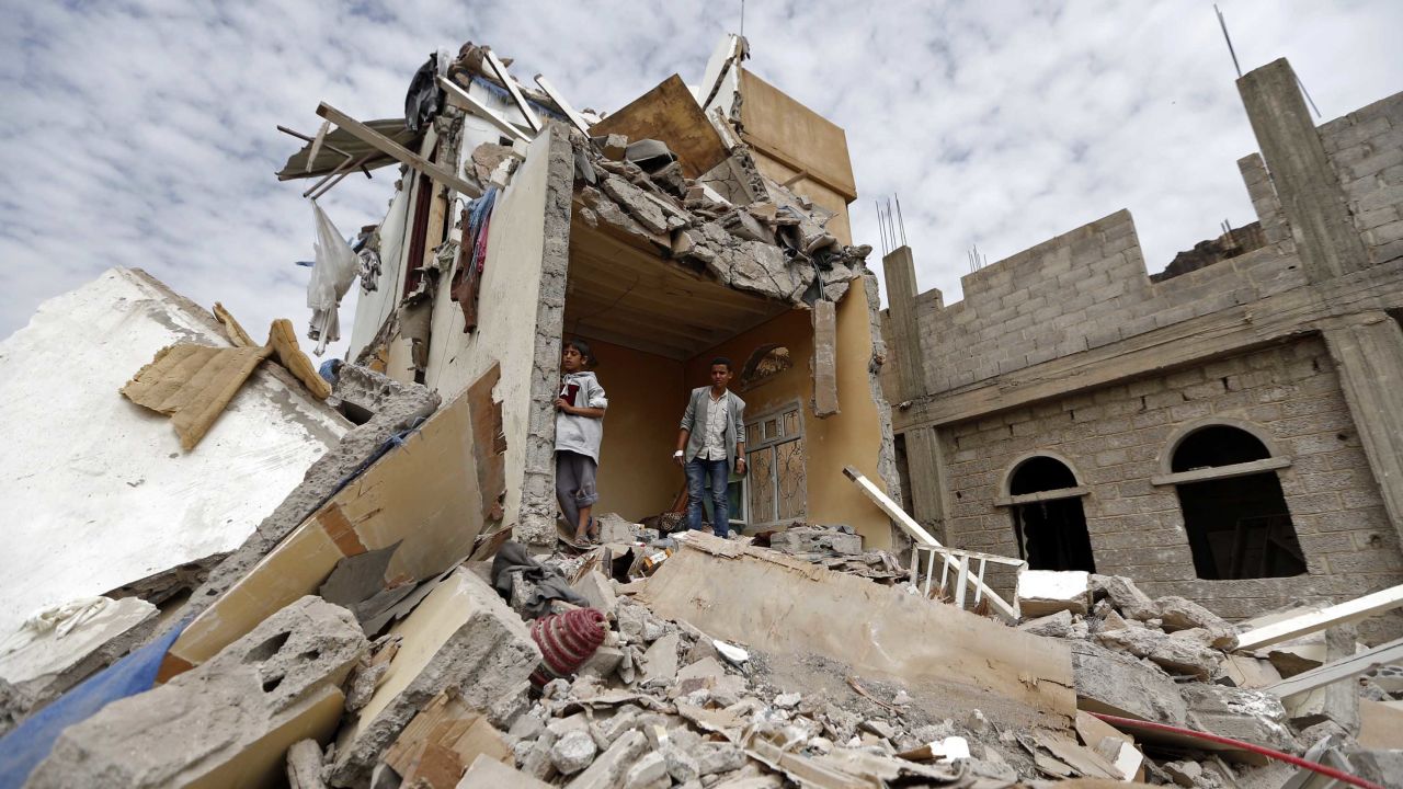 Yemenis stand in the rubble of a house destroyed Friday in an airstrike in Sanaa. 
