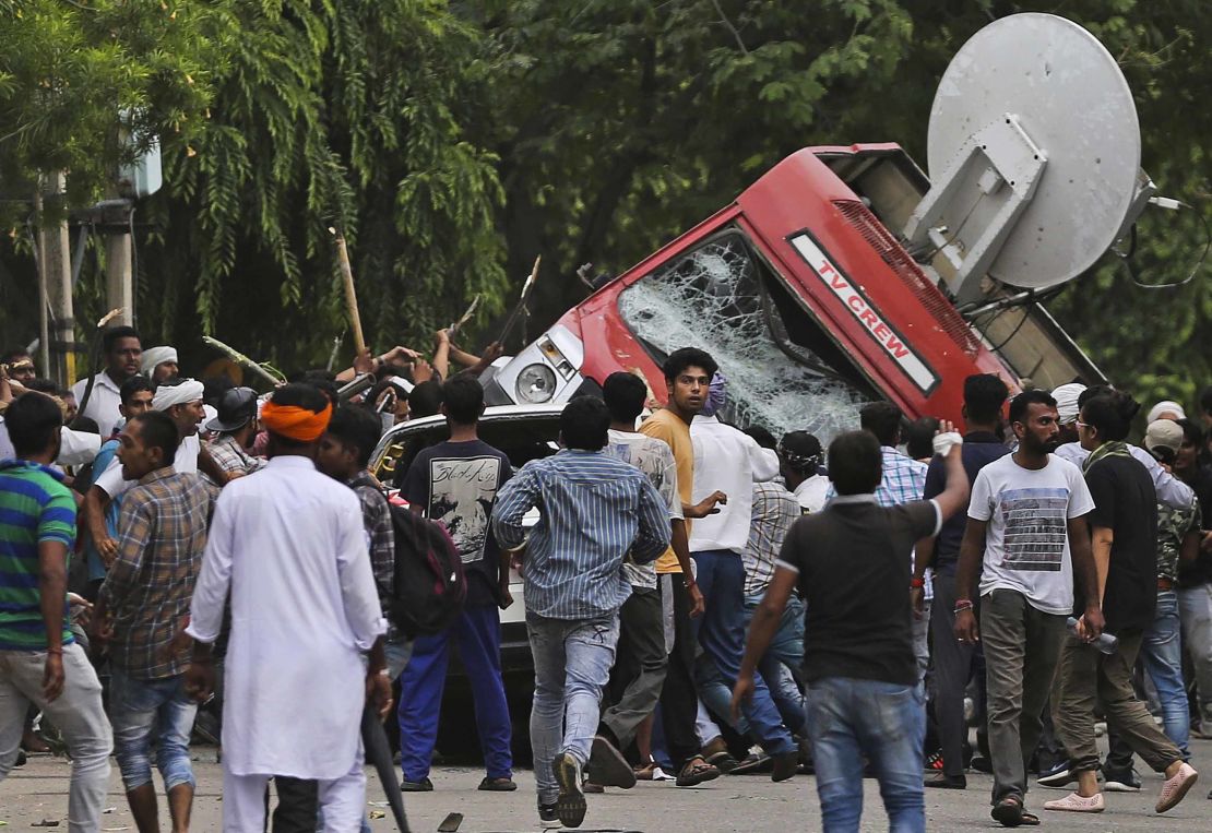 Followers of Gurmeet Ram Rahim Singh overturn a satellite van Friday in Panchkula, India. 