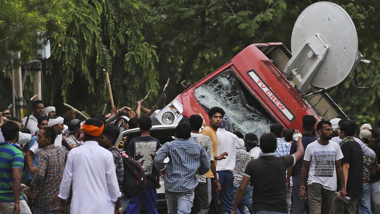 Followers of Gurmeet Ram Rahim Singh overturn a satellite van Friday in Panchkula, India.