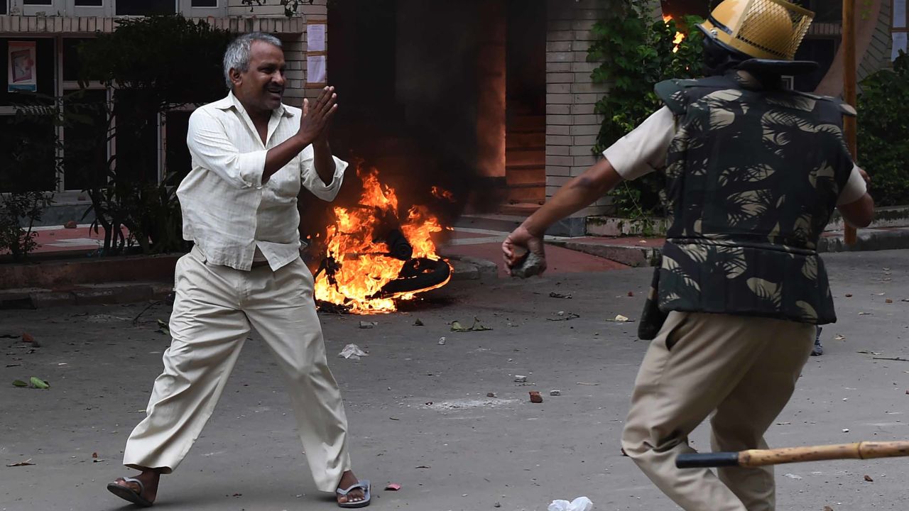 A follower of Indian religious leader Gurmeet Ram Rahim Singh pleads for his safety after being hit with a stick during clashes between the controversial guru's followers and security forces in Panchkula on August 25, 2017.