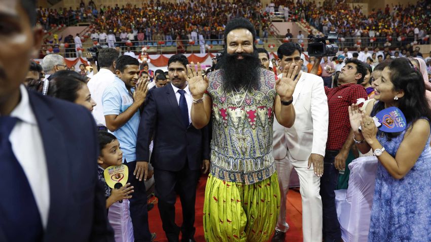 FILE- In this Oct. 5, 2016 file photo, Indian spiritual guru who calls himself Saint Dr. Gurmeet Ram Rahim Singh Ji Insan, center, greets followers as he arrives for a press conference ahead of the release of his new movie "MSG, The Warrior Lion Heart," in New Delhi, India. Several cities in north India were under a security lock down Thursday ahead of a verdict in a rape trial involving a controversial and hugely popular spiritual leader. (AP Photo/Tsering Topgyal, File)