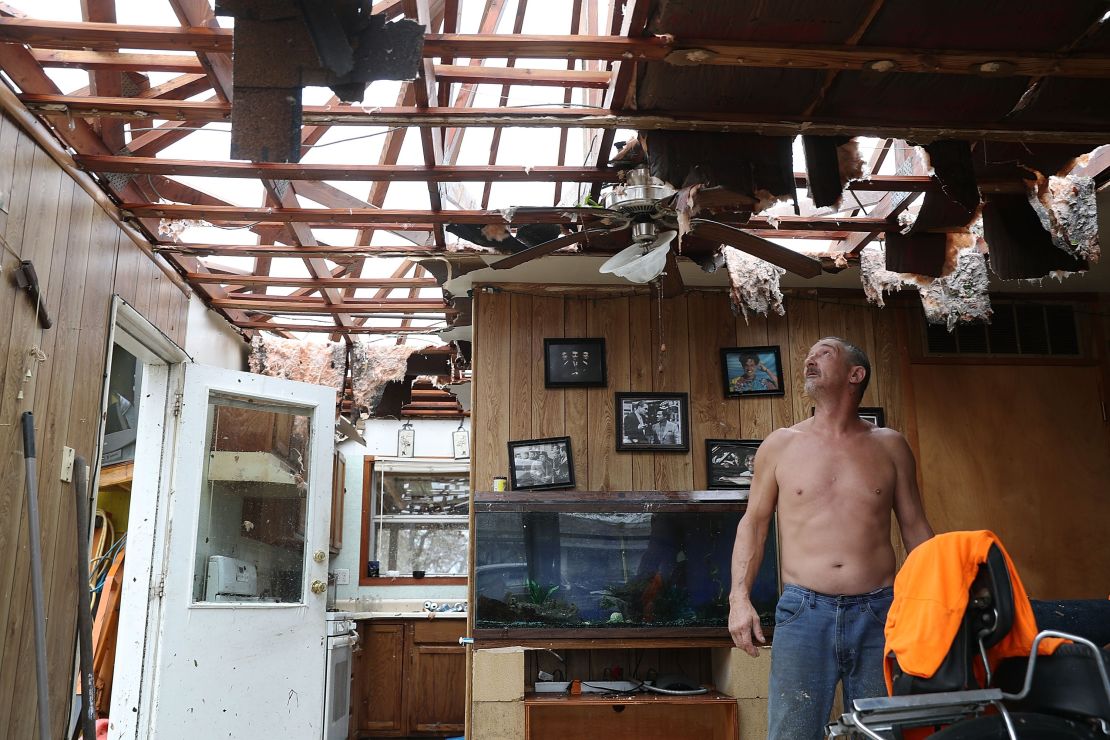 Aaron Tobias stands in what is left of his home in Rockport on Saturday. Tobias said he and his family lost everything in the storm.