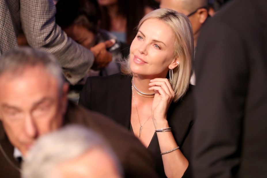 Actress Charlize Theron sits close to ringside.