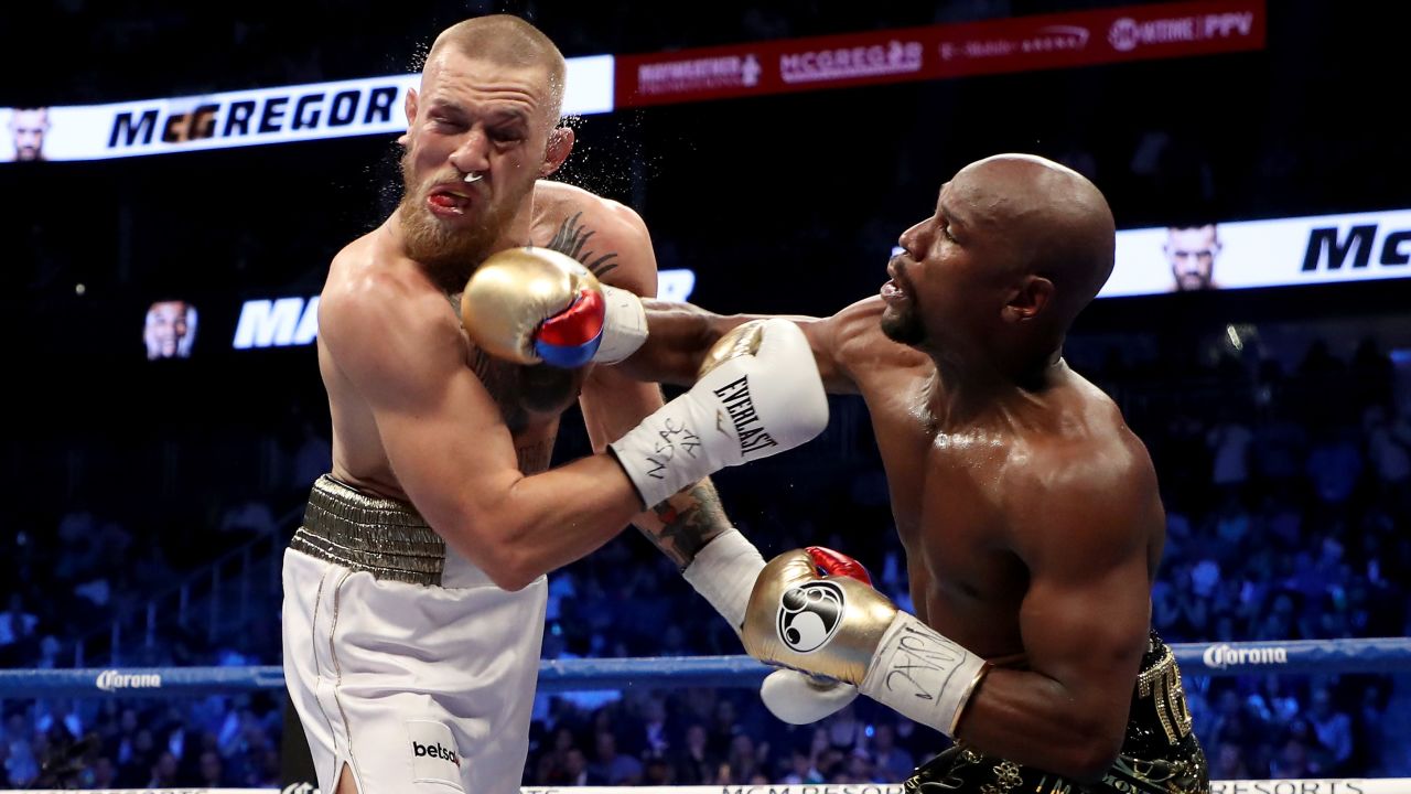 LAS VEGAS, NV - AUGUST 26:  (R-L) Floyd Mayweather Jr. throws a punch at Conor McGregor during their super welterweight boxing match on August 26, 2017 at T-Mobile Arena in Las Vegas, Nevada.  (Photo by Christian Petersen/Getty Images)