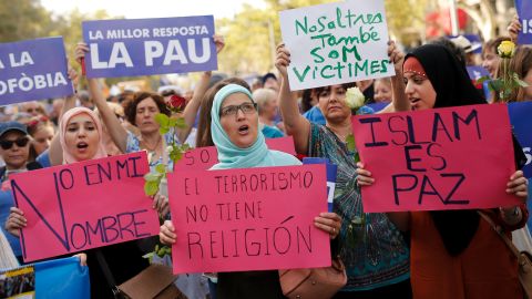 Muslim women hold placards reading "Not in my name," "Terrorism doesn't have a religion" and "Islam is Peace."