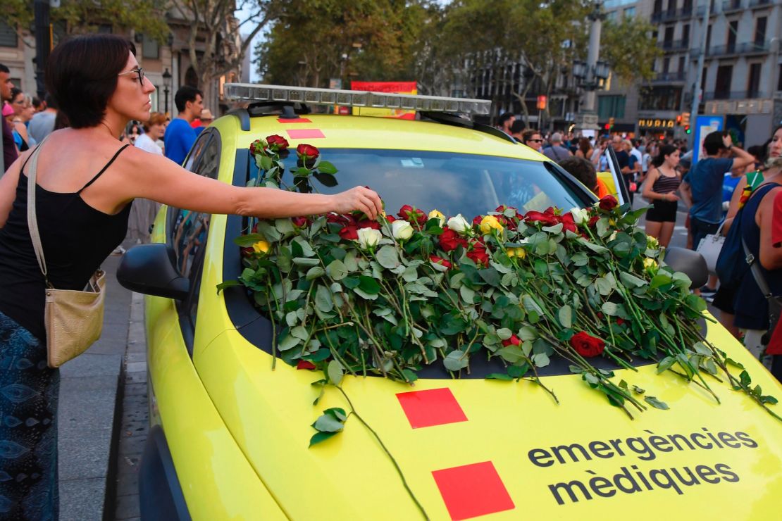 A woman places roses on an ambulance vehicle in Barcelona on Saturday. 