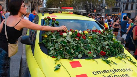 A woman places roses on an ambulance vehicle in Barcelona on Saturday. 