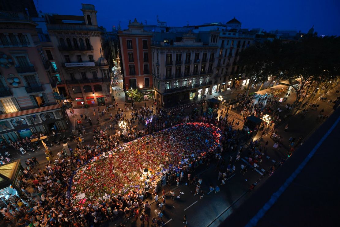 People gather around a flower tribute on Las Ramblas on Saturday to remember the victims of last week's deadly attacks.