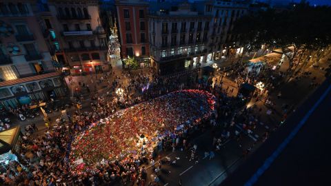 People gather around a flower tribute on Las Ramblas on Saturday to remember the victims of last week's deadly attacks.
