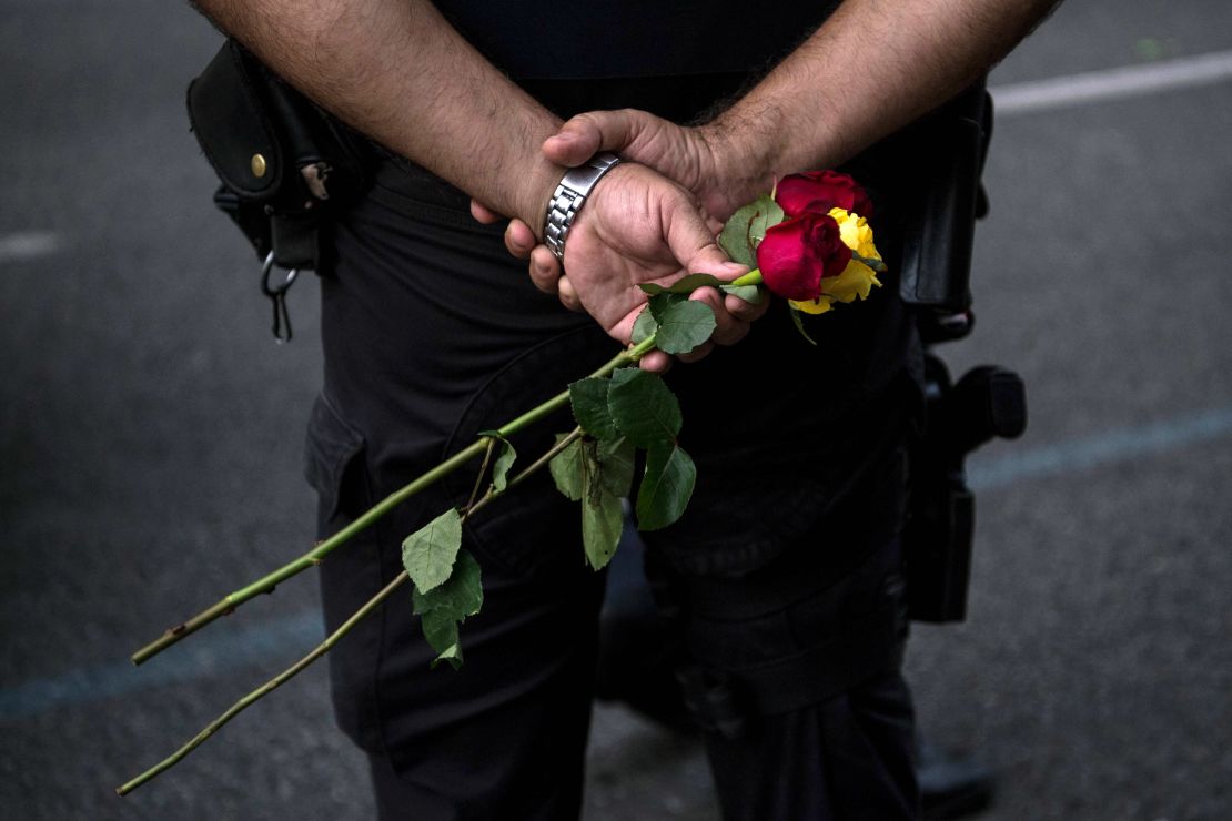 A police officer holds roses during the demonstration. 