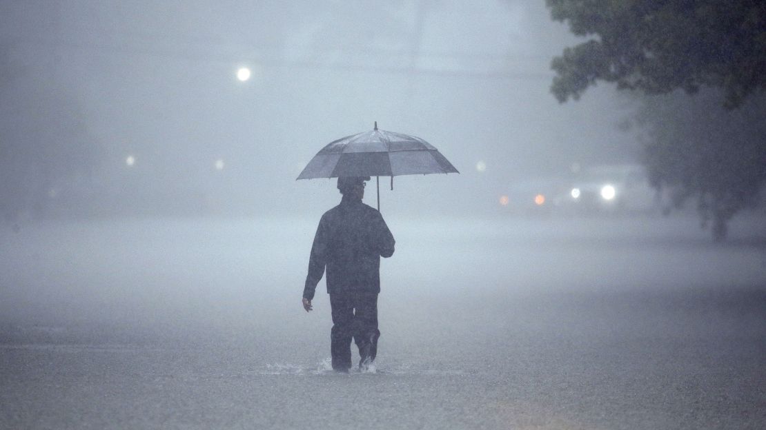 A man walks through deep water on Sunday in Houston.