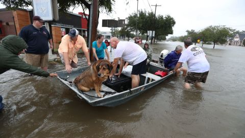 Neighbors use their personal boats to rescue flooded residents in Friendswood, Texas, on Sunday.