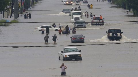 People walk through the flooded streets of Houston on August 27, 2017, after Hurricane Harvey dumped record rains.