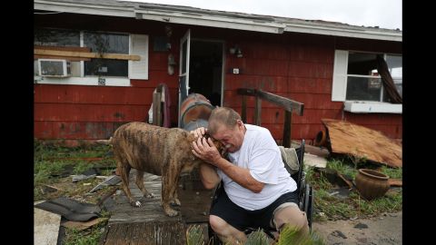 Steve Culver cries with his dog Otis as he talks about the "most terrifying event in his life," when Hurricane Harvey destroyed most of his home while he and his wife took shelter there on August 26, 2017 in Rockport, Texas.