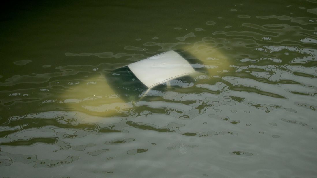 A car is submerged by floodwaters on a freeway near downtown Houston.