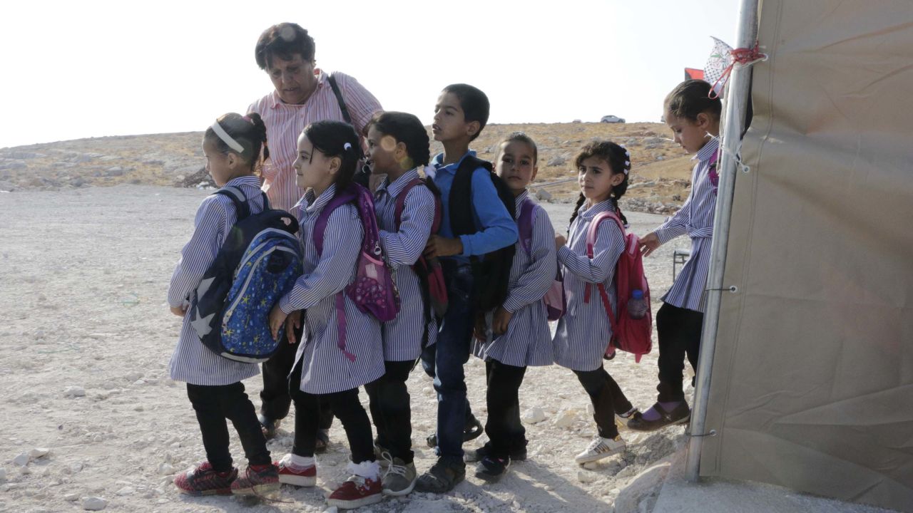 Teachers instruct children to stand in line before class begins.