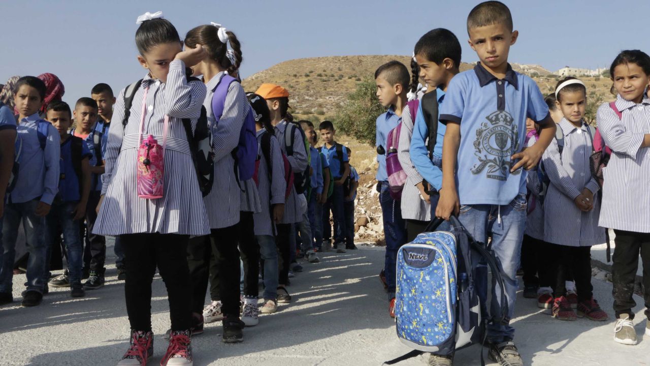Children, including Jana Zawahra (front left), stand in line near the remains of their school east of Bethlehem.