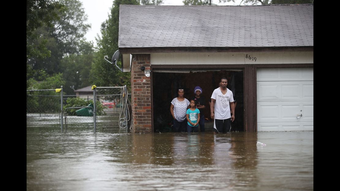 People wait to be rescued from their flooded home in Houston on August 28.