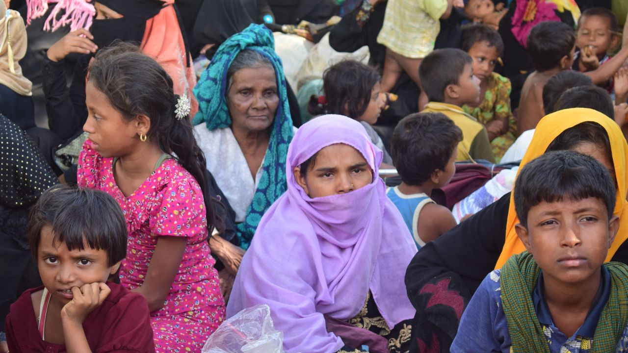 Rohingya woman Sayra Begum, wearing purple, sits with her relatives at a shelter in Cox's Bazar. 