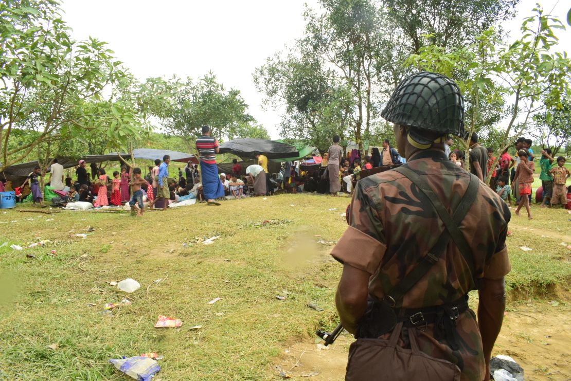 A Bangladeshi border guard soldier stands guard near a Rohingya refugee shelter, yards inside the border, in Cox's Bazar.