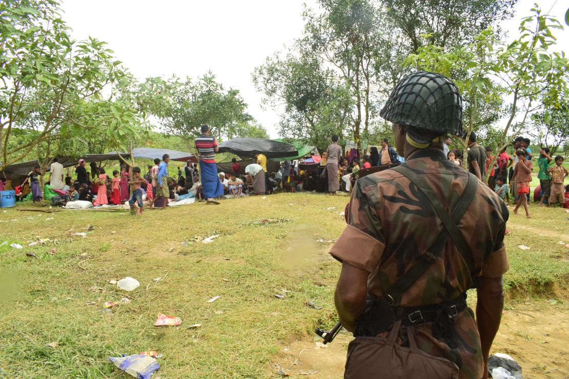 A Bangladeshi border guard soldier stands guard near a Rohingya refugee shelter, yards inside the border, in Cox's Bazar. 