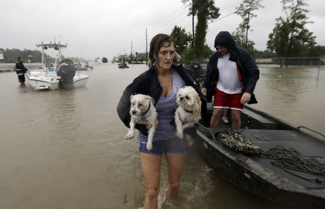 Belinda Penn holds her dogs Winston and Baxter after being rescued from their home as floodwaters from Tropical Storm Harvey rise Monday, Aug. 28, 2017, in Spring, Texas.