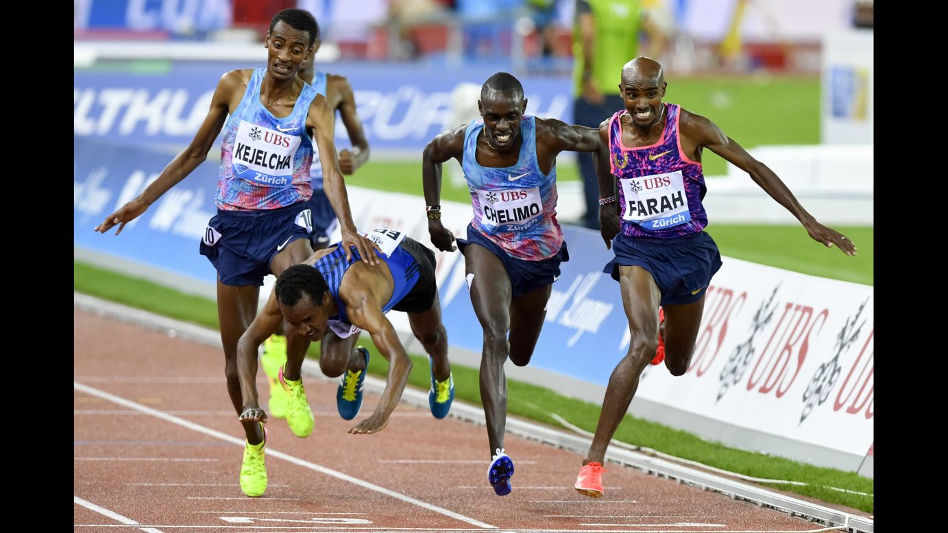 Ethiopia's Muktar Edris falls over the finish line during a 5,000-meter race in Zurich, Switzerland, on Thursday, August 24. British runner Mo Farah, right, finished first in what was the final race of his legendary career.