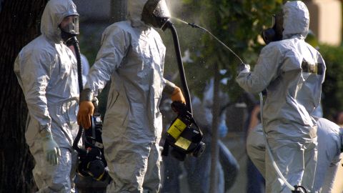 A hazardous-materials worker sprays his colleagues on October 23, 2001, after emerging from an anthrax search on Capitol Hill.