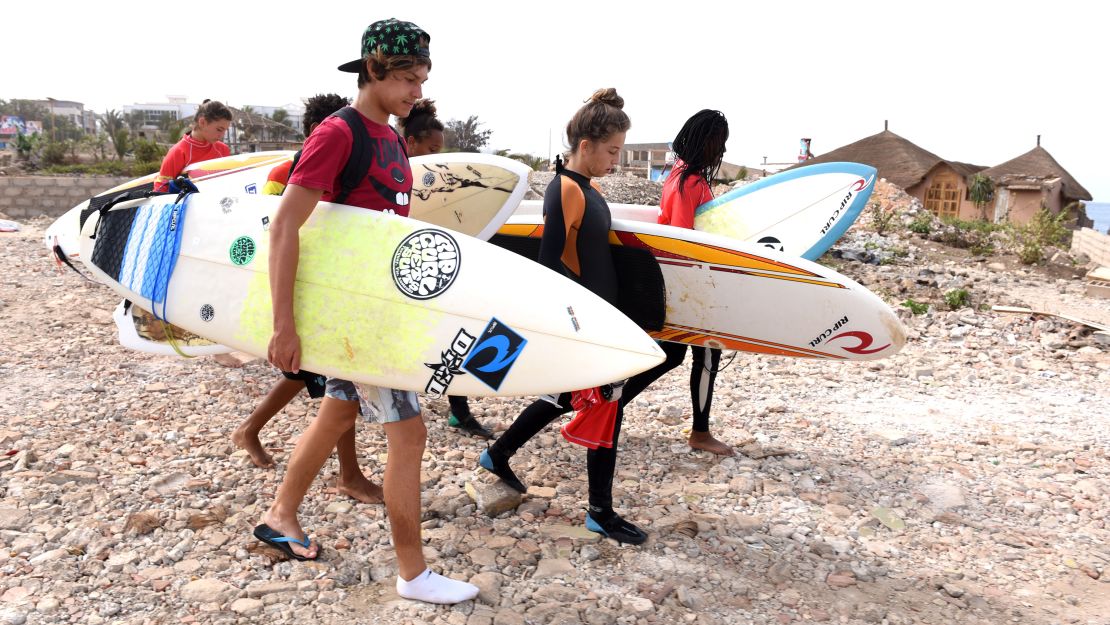 Students of the Rip Curl Surf Club Ngor surf school walk on the Almadie beach on May 23, 2015 in Dakar. 