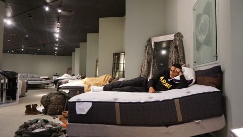 Aziz Shroff, 23, with the Texas National Guard, rests on a furniture store display mattress.