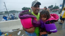 A man carries children after being rescued by members of the Louisiana Department of Wildlife and Fisheries and the the Houston Fire Department after residents were stranded by floodwaters due to Tropical Storm Harvey, Monday, Aug. 28, 2017. (AP Photo/Gerald Herbert)