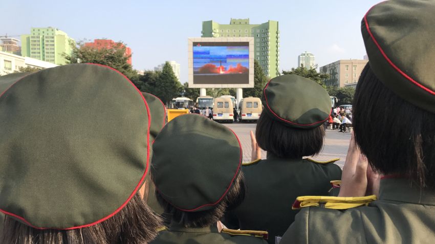 North Koreans watch news of the country's latest missile launch on an outdoor screen near Pyongyang's central railway station on August 30, 2017.
