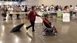 Narcedalia Osorio pushes her son Noel through a shelter set up inside NRG Center Wednesday, August 30, 2017, in Houston. 