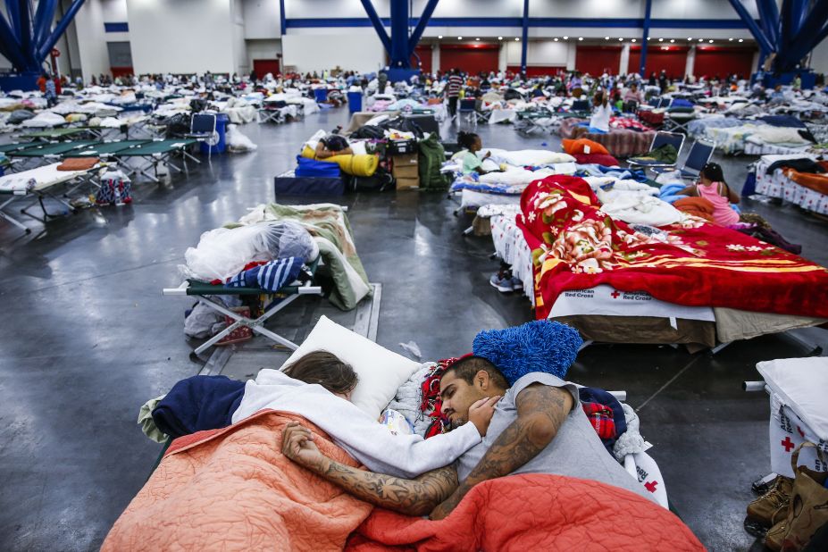 Tammy Dominguez and her husband, Christopher, sleep on cots at the George R. Brown Convention Center, where thousands of people were taking shelter in Houston.