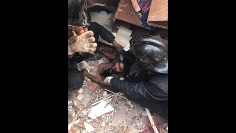 A victim is pulled from the debris as rescuers continue to search for more survivors.