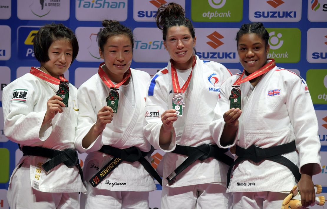 Japan's Tsukasa Yoshida, Mongolia's Sumiya Dorjsuren, France's Helene Receveaux and Great Britain's Nekoda Smythe-Davis show off their medals in the women's -57kg division. 